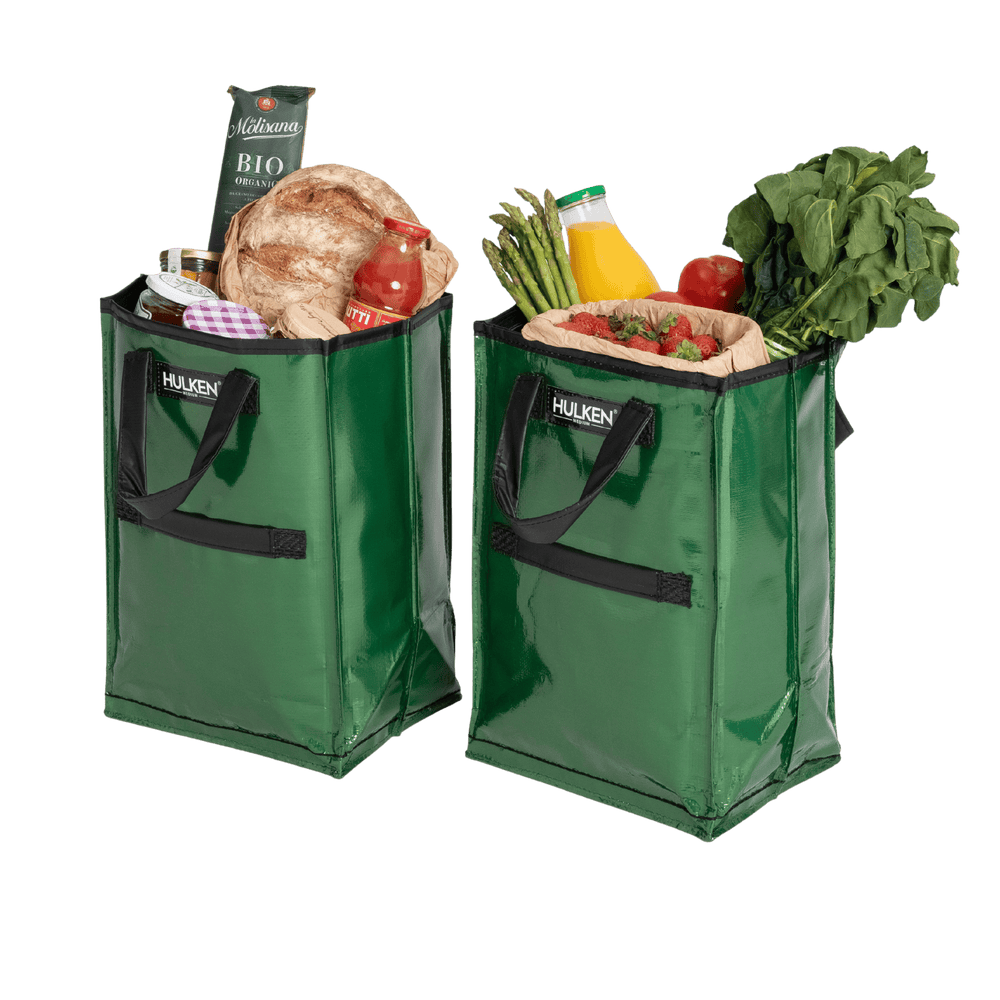Two green shopping bags filled with groceries on a transparent background